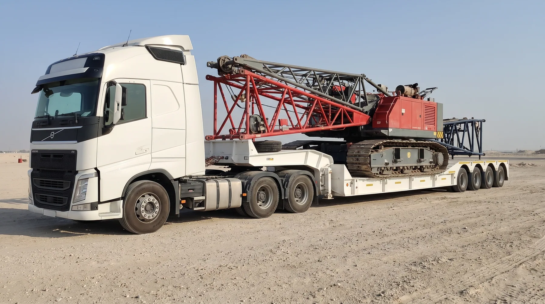 Crawler crane sections transported on a white lowbed trailer