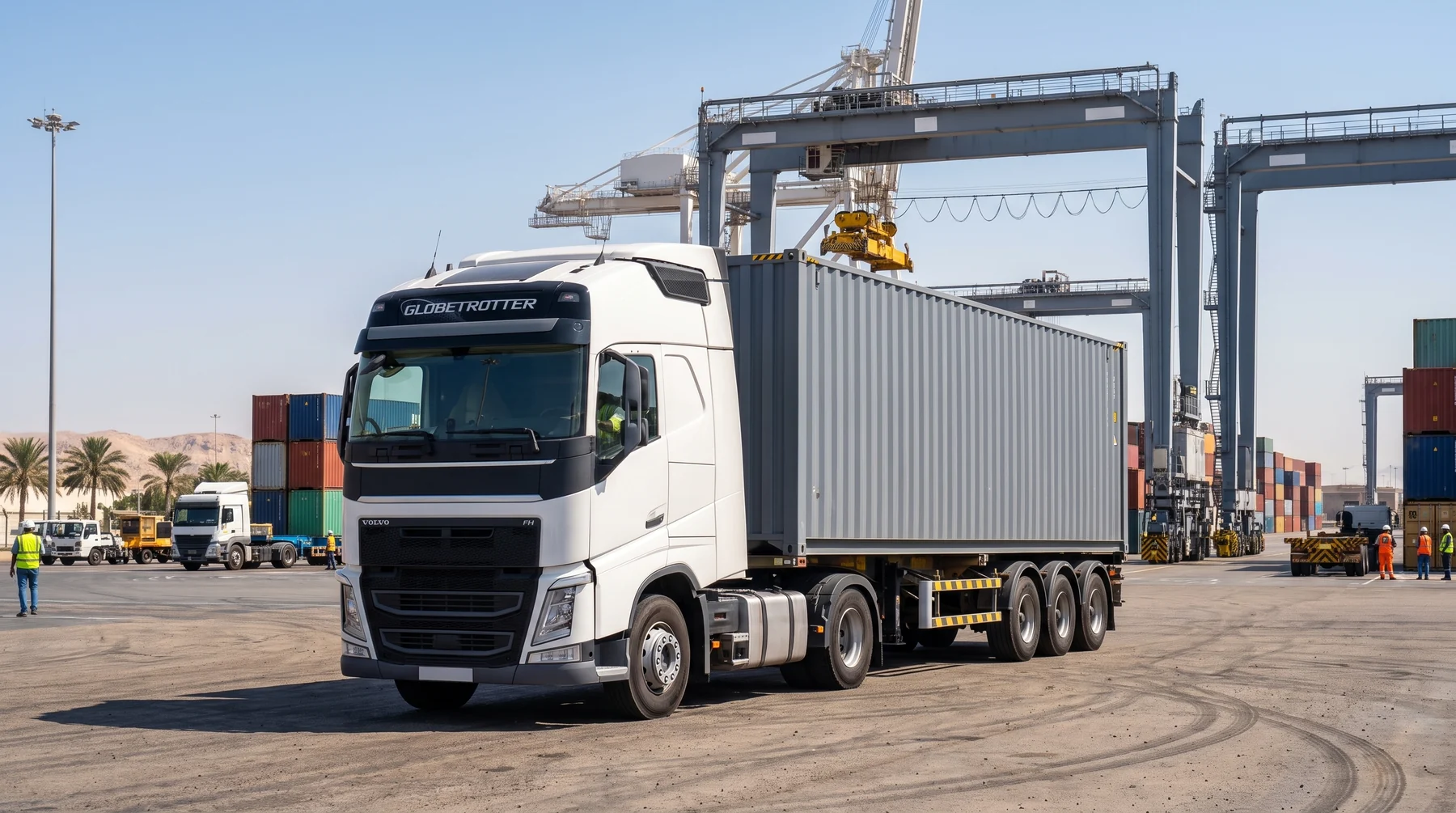 White truck hauling a loaded 40 ft shipping container past gantry cranes at a UAE container terminal